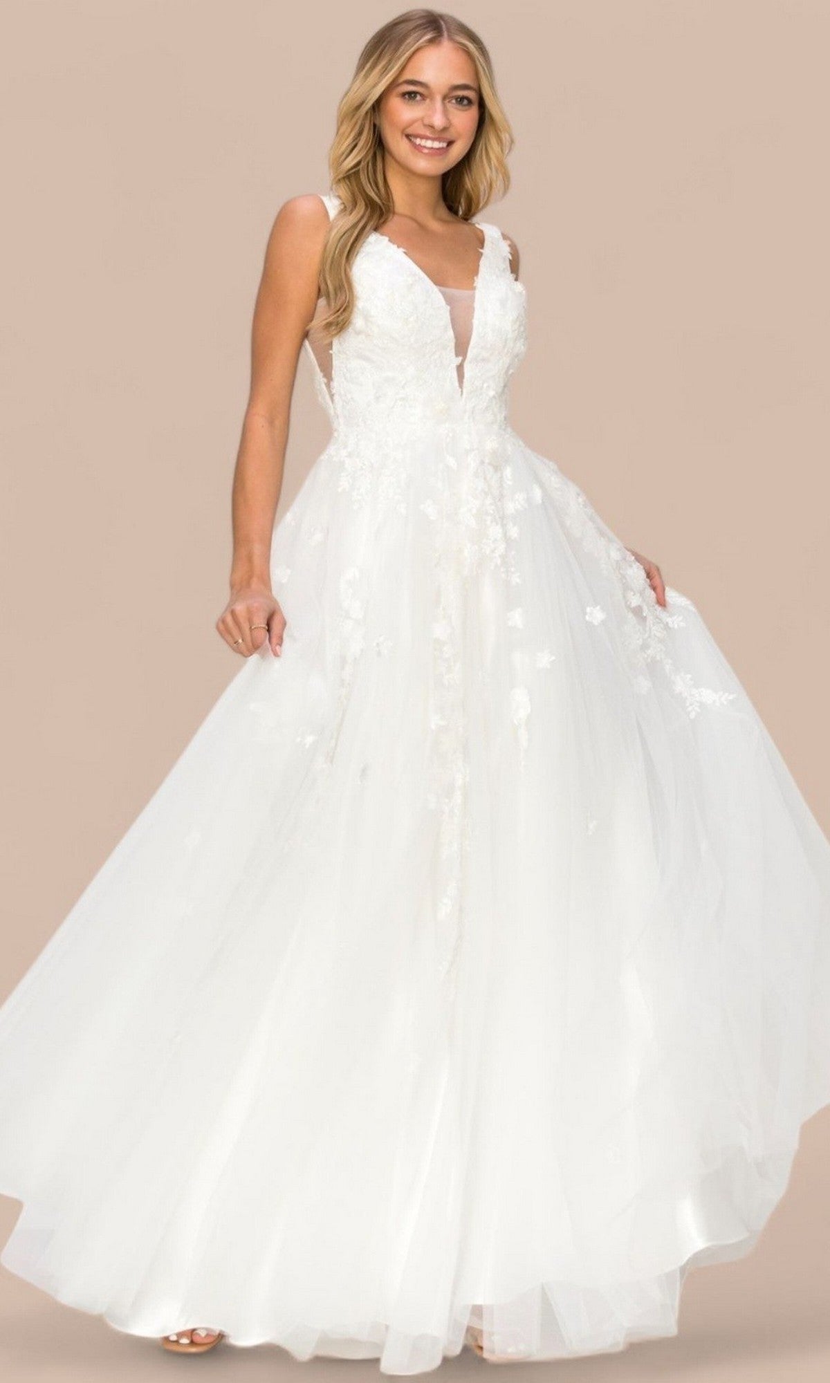 A woman wearing the Cinderella Couture 8040J long formal dress in white, featuring a sleeveless design with a lace bodice, tulle skirt, and 3D floral lace appliques, stands against a plain beige background.